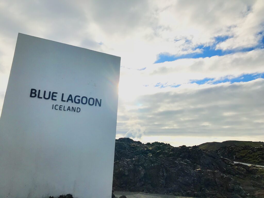 The Blue Lagoon Iceland Sign - a big white rectangle sign in front of black lava rock. 
