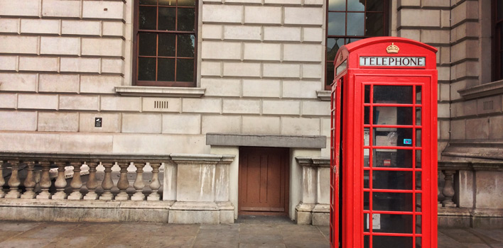 A red telephone booth along the roadside in London, England.