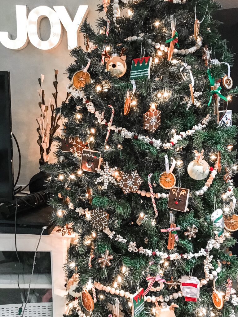 A full picture of a christmas tree covered in handmade ornaments.